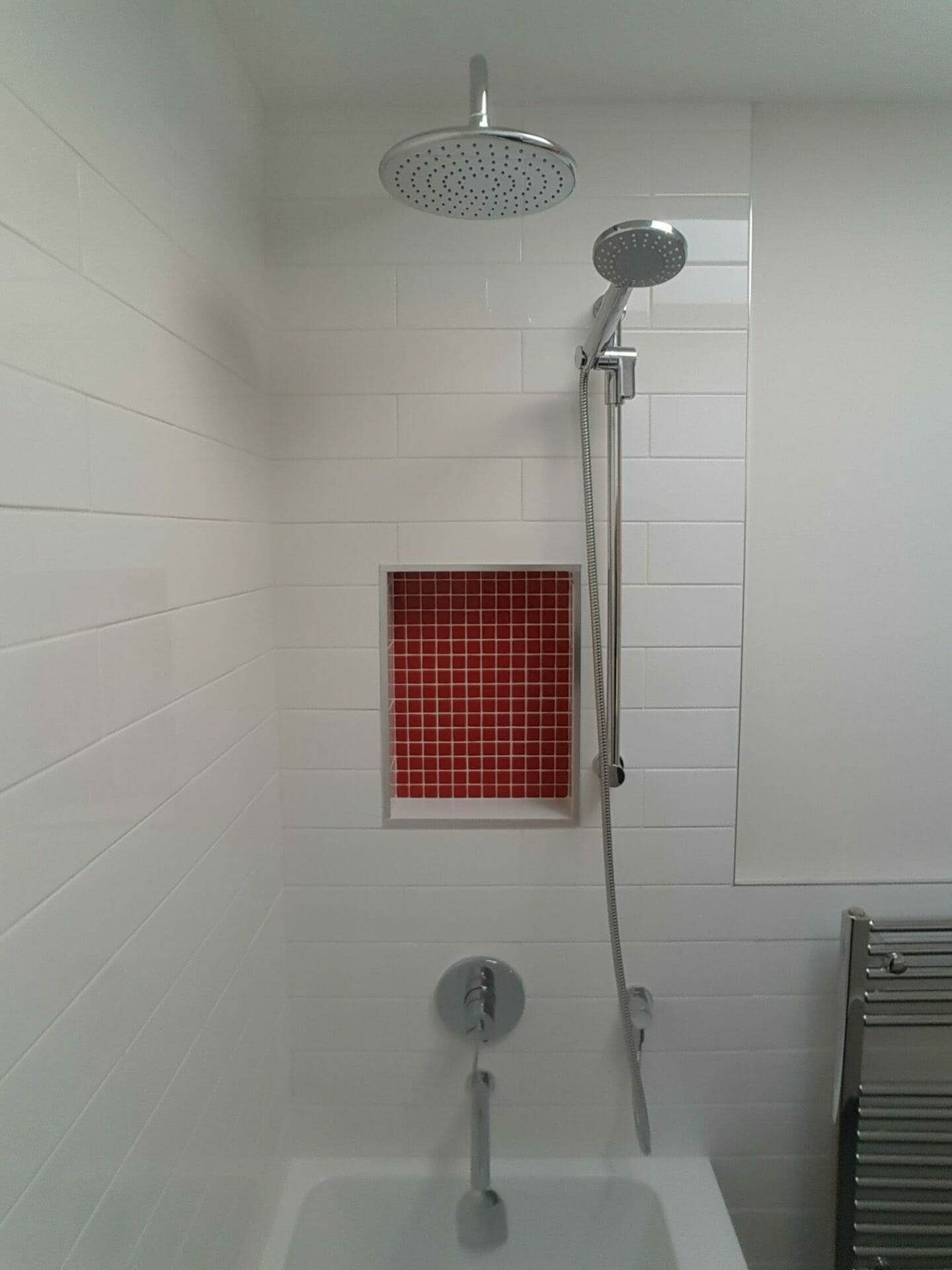 Beautiful white subway tiles and red tiled shower niche